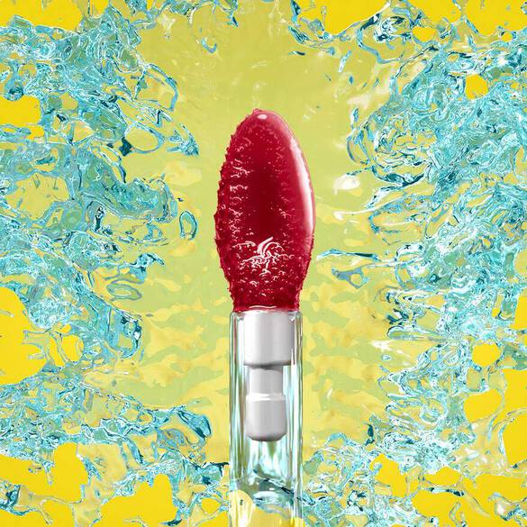 Rote Lippenpflege mit Wasserblasen vor einem gelben Hintergrund, der Frische und Vitalitat vermittelt.