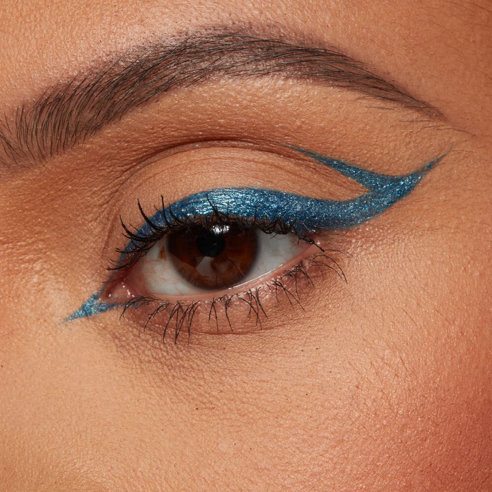 Nahaufnahme eines braunen Auges mit einem turkisenen Graphic Eyeliner Look