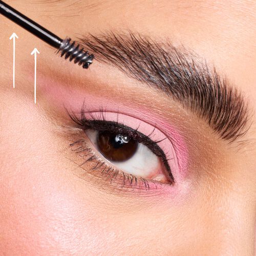 Auge mit rosa Lidschatten und gestylten Augenbrauen mit einem Augenbrauenburstchen am Ende der Braue