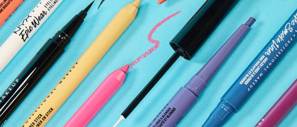 Verschiedene geoffnete NYX Eyeliner vor einem turkisen Hintergrund