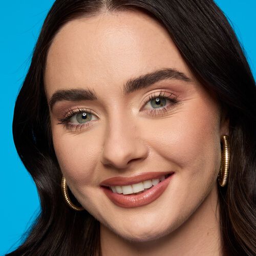 Frau mit dunklem Hautton schminkt sich dunkle Smokey Eyes