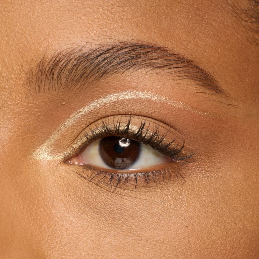 Nahaufnahme eines braunen Auges mit einem metallic Graphic Eyeliner-Look