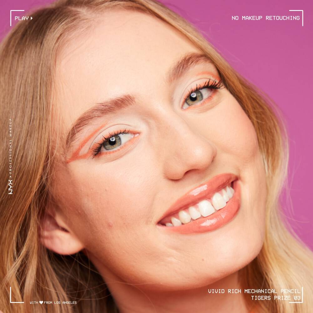 Frau mit orangem Eyeliner lachelt in die Kamera