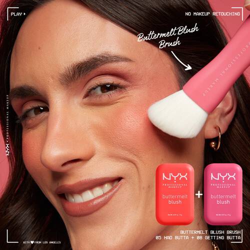 Nahaufnahme eines lachelnden Gesichtes auf dessen Wangen der Buttermelt Blush mit einem Pinsel aufgetragen wird