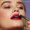 Frau mit dunklem Hautton schminkt sich dunkle Smokey Eyes