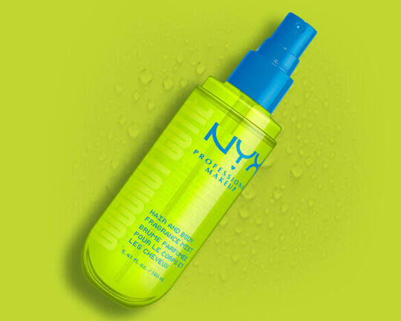 Das hellgrune NYX Coconut Cutie Hair and Body Fragrance Mist mit blauem Spruhkopf vor einem grunen Hintergrund mit Wassertropfen.