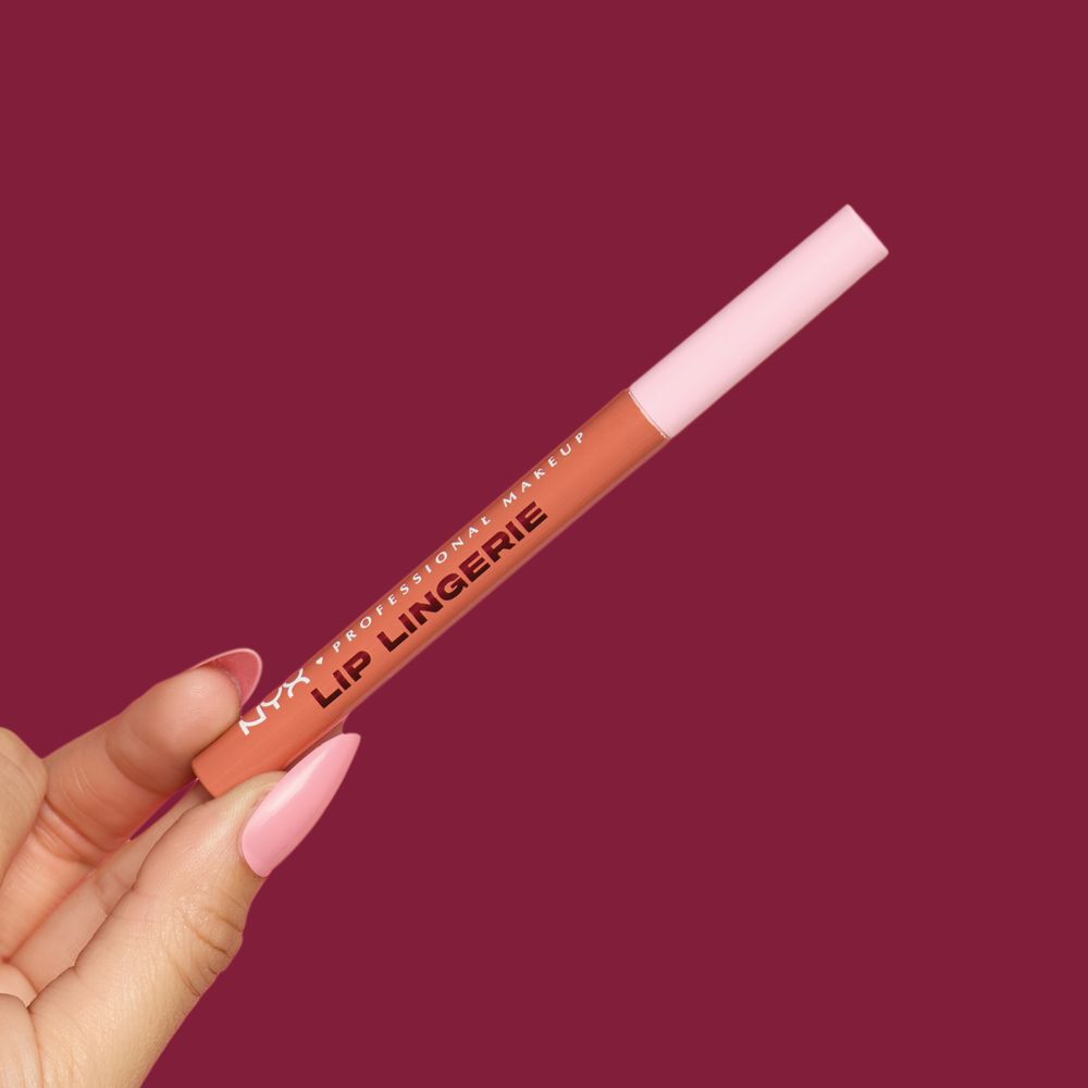 Hand halt den NYX Lip Lingerie Lip Stain Lipliner in der Hand, vor weinrotem Hintergrund