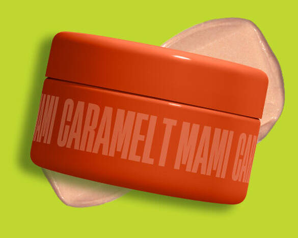 Ein orangefarbener Tiegel der NYX Fat Oil Shimmer Body Butter „Caramelt Mami“ mit einem schimmernden Produkt-Swatch auf leuchtend grunem Hintergrund.
