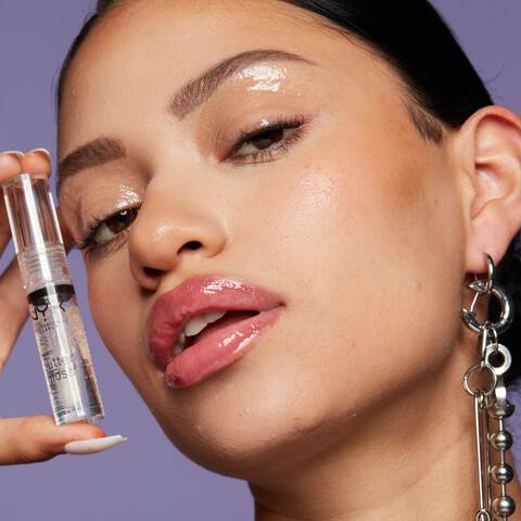 Frau mit glossy Make Up halt den Butter Gloss Lipgloss neben das Gesicht