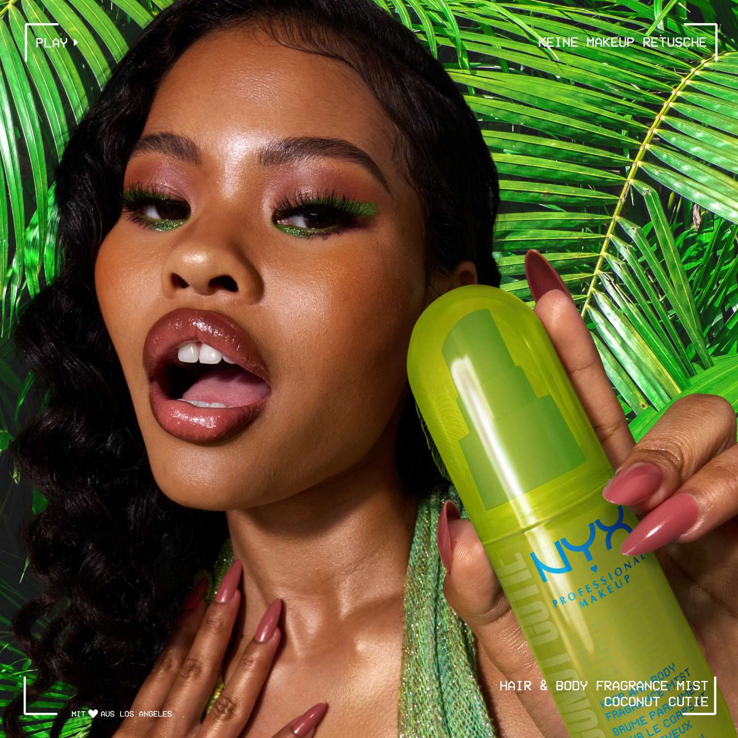Ein Model prasentiert das Coconut Cutie Fragrance Mist vor einem tropischen Hintergrund aus grunen Palmblattern.