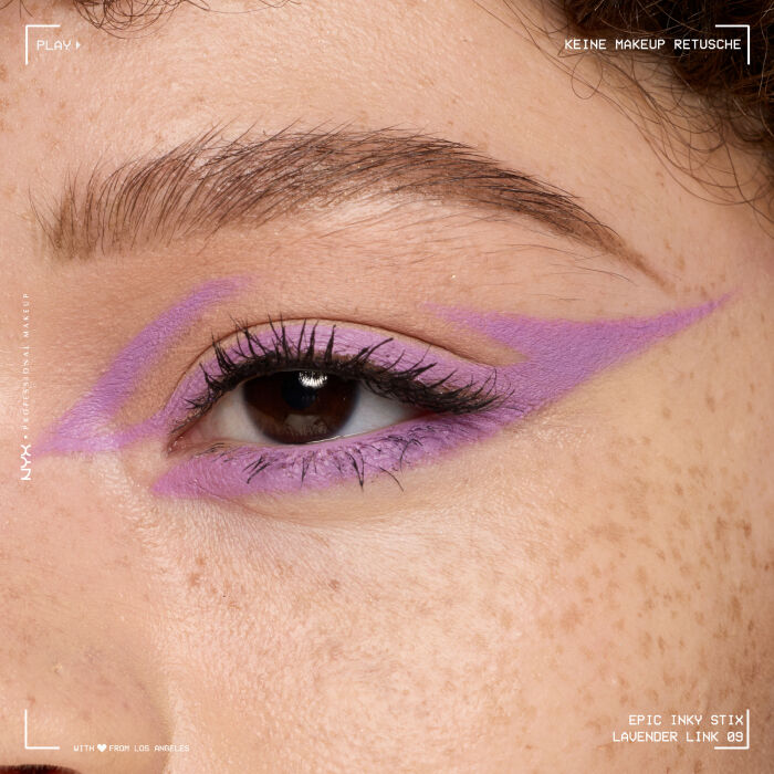 Nahaufnahme eines Auges mit einem aufwendigen Eyeliner-Design. Der Eyeliner beginnt am oberen Wimpernkranz, zieht sich uber das Lid und formt mehrere geschwungene, tribalahnliche Linien, die sich bis zur Augenbraue erstrecken und ein markantes, grafisches Muster bilden.