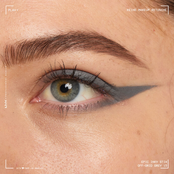 Nahaufnahme eines Auges mit einem aufwendigen Eyeliner-Design. Der Eyeliner beginnt am oberen Wimpernkranz, zieht sich uber das Lid und formt mehrere geschwungene, tribalahnliche Linien, die sich bis zur Augenbraue erstrecken und ein markantes, grafisches Muster bilden.