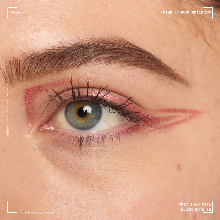 Nahaufnahme eines Auges mit einem aufwendigen Eyeliner-Design. Der Eyeliner beginnt am oberen Wimpernkranz, zieht sich uber das Lid und formt mehrere geschwungene, tribalahnliche Linien, die sich bis zur Augenbraue erstrecken und ein markantes, grafisches Muster bilden.