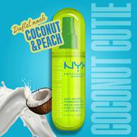 Das Coconut Cutie Fragrance Mist wird dekorativ mit einer Kokosnuss und einem Milchsplash vor hellblauem Hintergrund inszeniert.