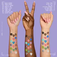 Drei Hande mit unterschiedlichen Hauttonen, die alle lange, rosafarbene Nagel tragen, sind vor einem hellvioletten Hintergrund zu sehen. Auf den Unterarmen sind 17 diamantformige Farbmuster zu sehen, die verschiedene Farben zeigen.