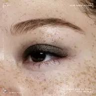 Nahaufnahme eines Auges mit dem NYX Professional Makeup Party Animals Lid Lingerie Cream Eye Pigment in Gothic Garter, einer tiefen metallic-schwarzen Nuance.
