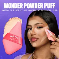 Frau mit dunklem Haar tragt mit dem Wonder Powder Puff hellen Puder auf ihr Gesicht an, daneben ein zweiter Puff und loser Puder, vor einem violetten Hintergrund.
