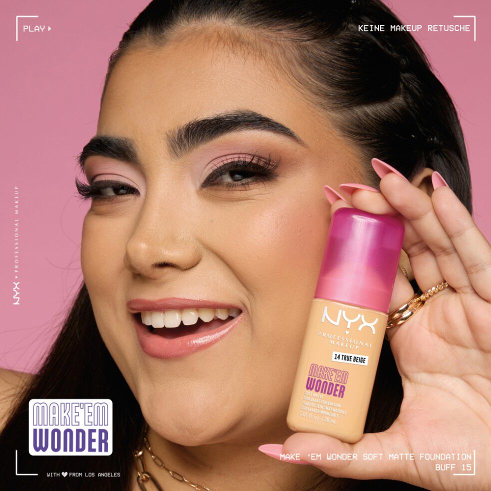 Lachelnde junge Frau halt die Make 'Em Wonder Foundation in die Kamera