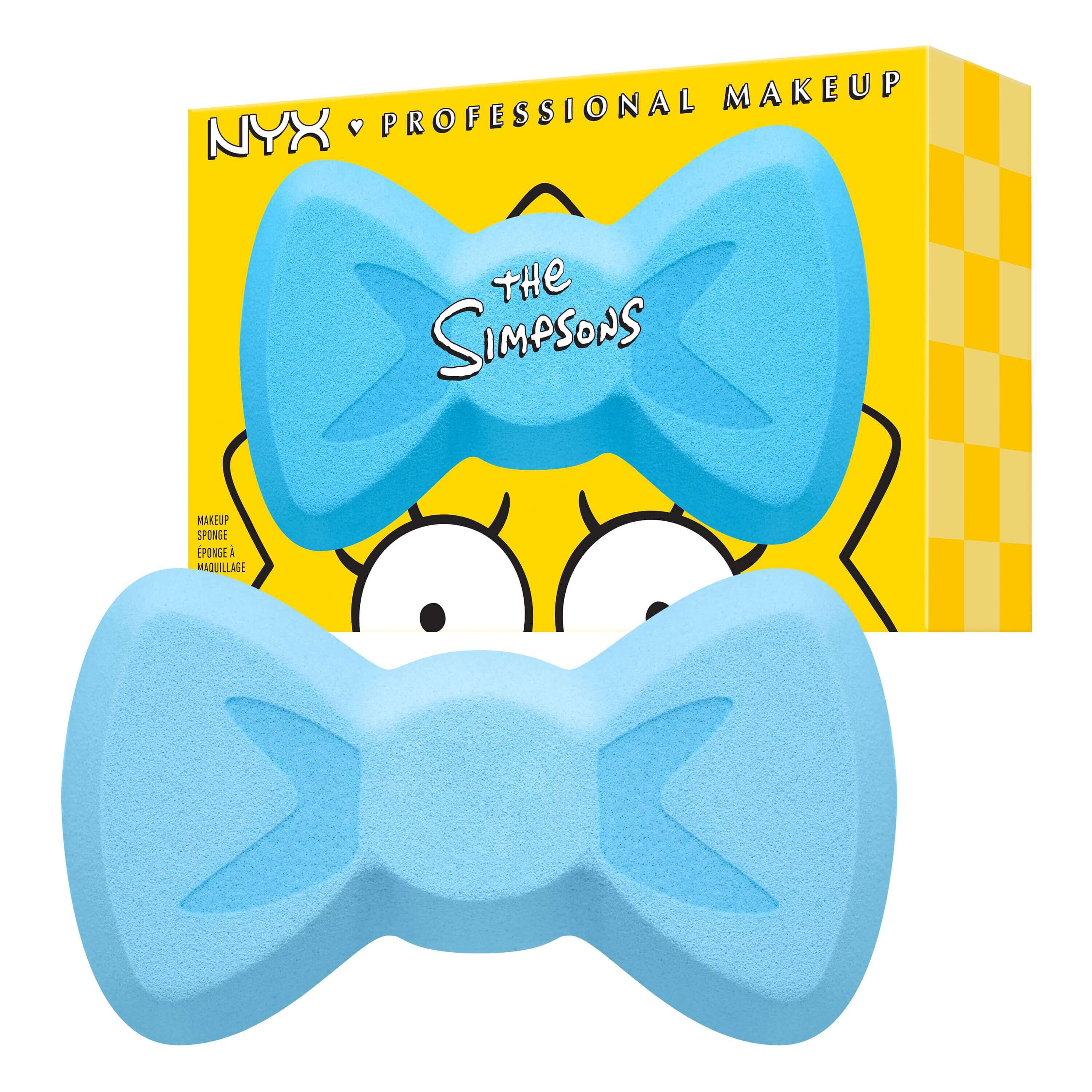 Der hellblaue Maggie Simpson Bow Make-up-Schwamm von NYX Professional Makeup in seiner charakteristischen Schleifenform vor der gelben Verpackung.