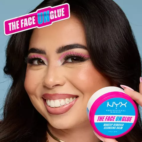 Lachelnde Frau mit Augen-Make-up halt die Dose des „The Face Unglue“ Cleansing Balms in die Kamera.