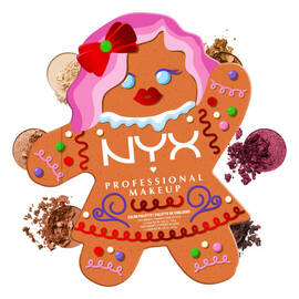 Zeigt die geschlossene NYX Professional Makeup Holiday Gingerbaddie Palette, umgeben von verstreuten losen Lidschattenpigmenten, die Farbtone aus der Palette sind.