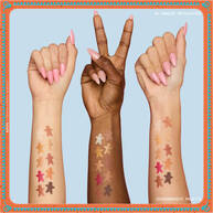 Zu sehen sind drei Arme in verschiedenen Hauttonen, auf denen jeweils Farbmuster der Lidschatten aus der NYX Professional Makeup Holiday Gingerbaddie Palette zu sehen sind, um zu veranschaulichen, wie die Farben auf unterschiedlichen Hauttypen wirken.