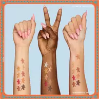 Zu sehen sind drei Arme in verschiedenen Hauttonen, auf denen jeweils Farbmuster der Lidschatten aus der NYX Professional Makeup Holiday Gingerbaddie Palette zu sehen sind, um zu veranschaulichen, wie die Farben auf unterschiedlichen Hauttypen wirken. 